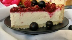 Kousek cheesecake na talíři s lesním ovocem, borůvkami a malinami na ozdobu.